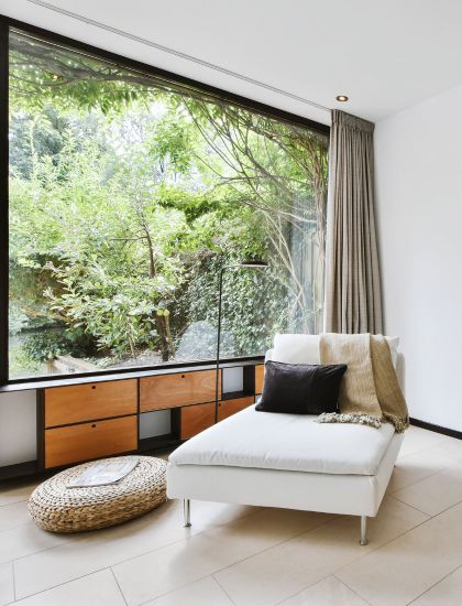 Luxury living space with large window and view of forest 
