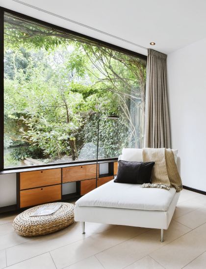 Luxury living space with large window and view of forest